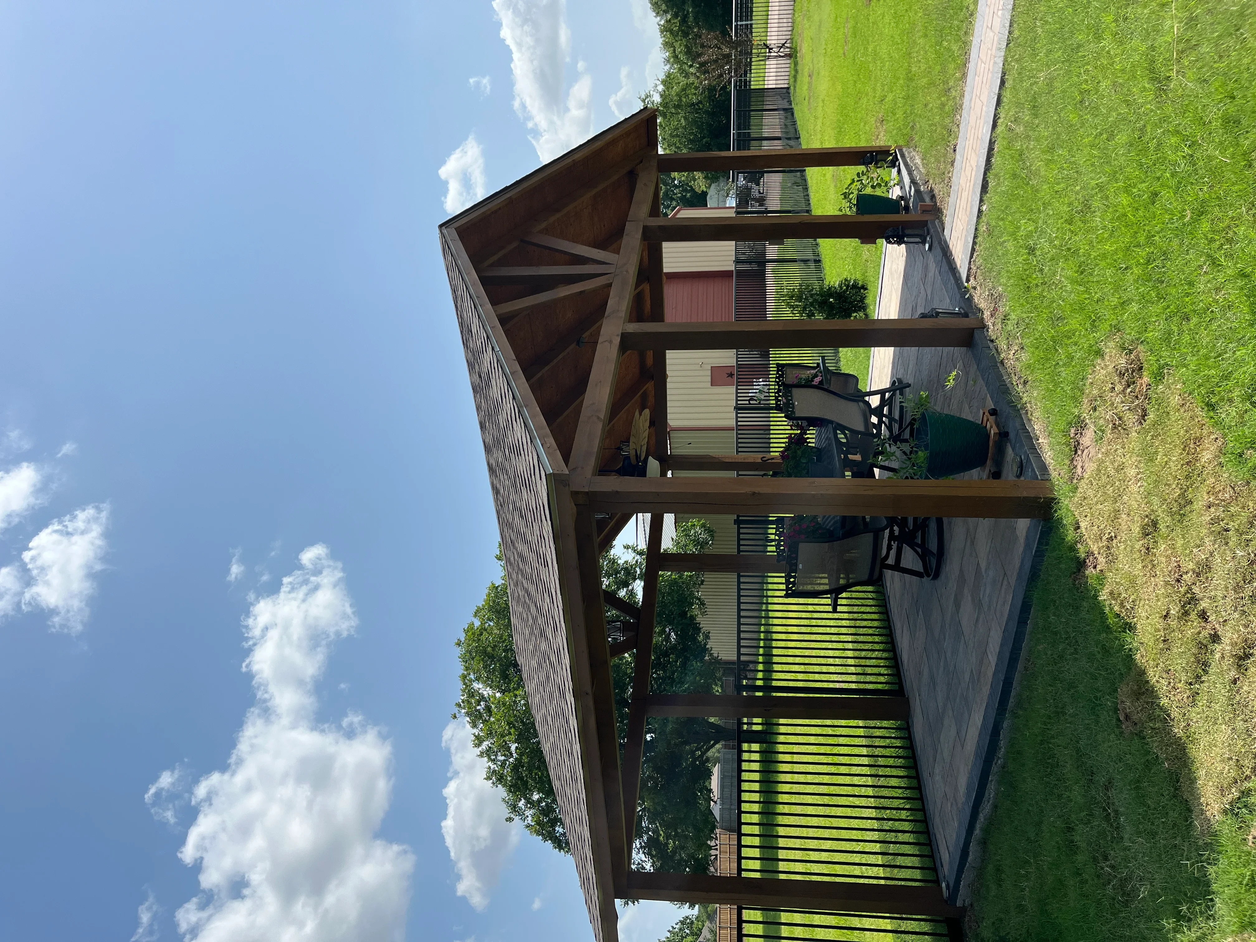 Wood pergola deck with horizontal slats and timber framing over composite decking